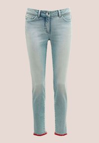 Hellblaue Jeans im geraden Schnitt, mit einem roten Pomponbesatz am Knöchel und klassischem Fünf-Taschen-Design. Metallischer Knopfverschluss.