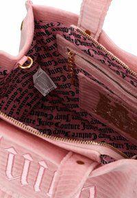 Borsa in corduroy rosa di Juicy Couture con zip dorata e logo, che mostra l'interno foderato con script nero di Juicy Couture su tessuto rosa.