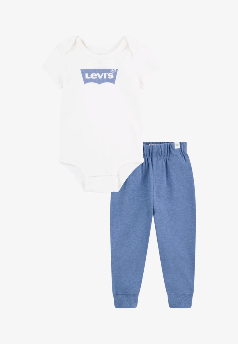 Body bianco a maniche corte con logo blu di Levi's, abbinato a pantaloni di cotone blu con cintura elastica e polsini a costine.