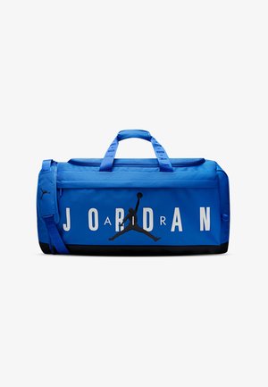 Blue duffel bag in durable material, featuring a horizontal zipper, carrying handles, black accents, large "JORDAN" text, and logo design.