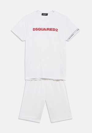 Bela bombažna kratka majica s kratkimi rokavi in kratke hlače. Majica ima rdeč tisk "DSQUARED2" na sprednji strani in manšete z rdečimi poudarki.