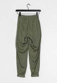 Olivgröna joggers med elastisk midja, två bakfickor och elastiska muddarna vid anklarna. Slätt tyg med en avslappnad passform.