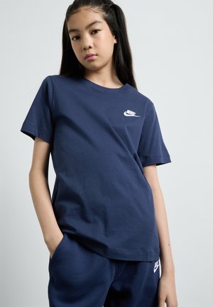 Tumed sinine puuvillane T-särk, millel on rindkeres väike valge Nike logo. Tavaline lõige, lühikesed varrukad ja ümar kaelus.