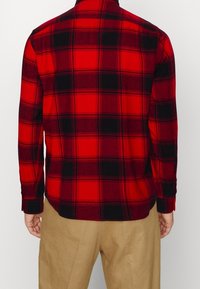 Rood en zwart geruit overhemd met lange mouwen, knoopsluiting bij de kraag en een zachte textuur, met een rechte zoom en een getailleerde pasvorm.