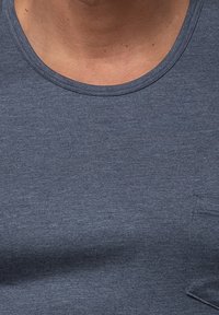 Navy blue crew neck t-paita, joka on valmistettu tekstuuripinnasta ja jossa on pieni rintatasku. Sileä ulkonäkö, jossa on hienovaraisia värivaihteluita.