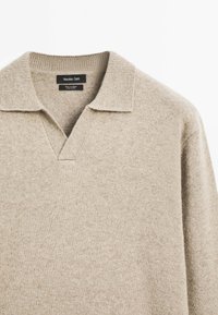 Beige cashmere polo sweater met een geribbelde kraag, V-halsontwerp en lange mouwen met een zachte, gemarmerde afwerking.
