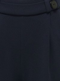 Pantalon en tissu bleu marine foncé avec une ceinture haute et un grand bouton noir sur le côté droit.