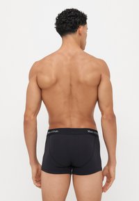 Schwarze Baumwoll-Trunkunterwäsche mit enger Passform, ausgestattet mit einem weichen, elastischen Bund, der mit "Marc O'Polo" gekennzeichnet ist. Das Design ist minimalistisch und glatt.