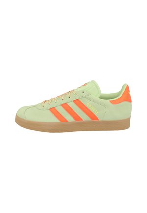 Sneakers Adidas Gazelle w jasnozielonym zamszu z pomarańczowymi akcentami, z trzema paskami i teksturowaną gumową podeszwą.