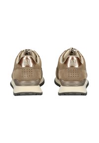 Para beżowych zamszowych sneakersów z metalicznymi brązowymi akcentami na pięcie, perforowanymi detalami, czarnymi podeszwami i markowymi pętelkami, widoczna z tyłu.