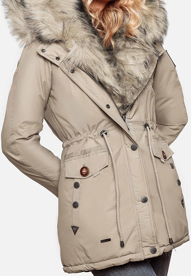 Beige parka-takki, jossa on tekoturkiksesta valmistettu huppu, kuminauhakiristys vyötäröllä, kaksi etutaskua nappikiinnityksellä ja teksturoitu kangas.