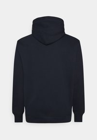 Marinblå hoodie med stor huva, ribbade muddar och fåll. Tillverkad av mjukt tyg med slät yta. Enkel design utan synliga logotyper eller detaljer.