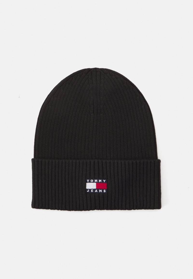 Gorro de malha preto com uma textura canelada. Apresenta uma aba dobrada e um pequeno logótipo bordado em vermelho, branco e azul na frente.