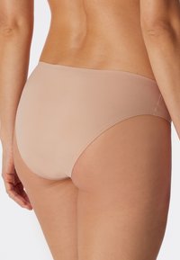 Beige Hipster-Unterwäsche aus glattem Material, mit nahtlosem Design und mittlerer Bedeckung am Rücken. Keine sichtbaren Muster oder Verzierungen.