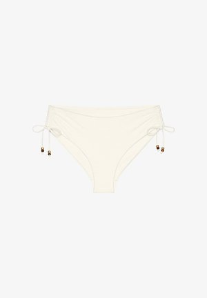 Białe dółki bikini z regulowanymi wiązaniami po bokach, ozdobione małymi brązowymi i złotymi koralikami na każdym końcu.