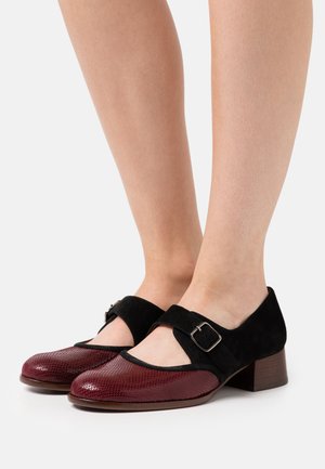 Chaussures Mary Jane en suède noir et en faux serpent rouge avec un petit talon carré et une sangle à boucle sur le dessus.