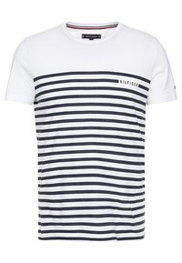 Camiseta blanca de algodón con franjas horizontales en azul marino, que presenta un pequeño logo de "Hilfiger" en el lado izquierdo del pecho. Cuello redondo clásico, mangas cortas.