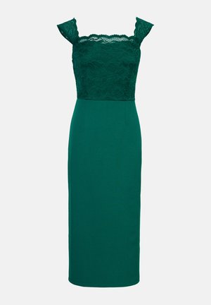 Robe verte émeraude avec un corsage en dentelle et une jupe ajustée. Encolure droite avec manches courtes, fabriquée dans un mélange de tissus lisses. Longueur mi-mollet.