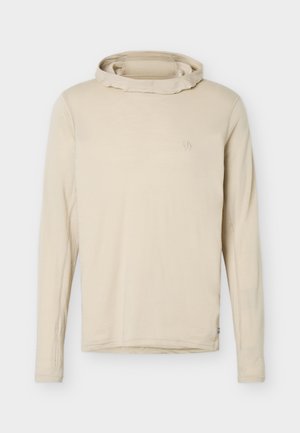 Beiges Kapuzenlangarmshirt mit dezentem Logo auf der Brust und Daumenlochbündchen, präsentiert vor weißem Hintergrund.