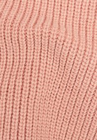Ljust rosa stickad tyg med ribbad struktur, med vertikala ränder som skapar ett mjukt, elastiskt utseende.