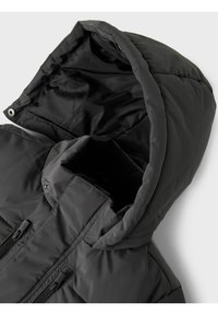 Sort polstret jakke med høj krave, stor hætte og to frontlommer med lynlås. Glat, skinnende ydre med minimale hardware-detaljer.