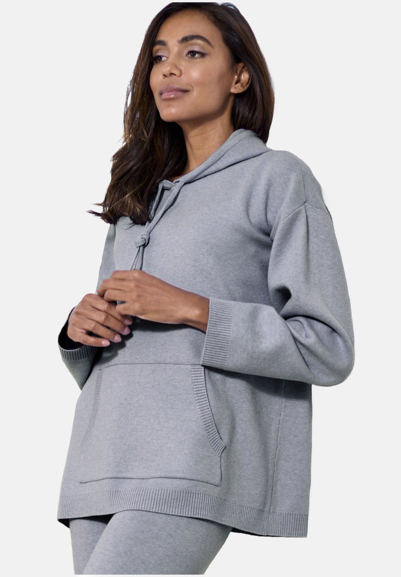 Grauer Kapuzenpullover mit lockerer Passform, gerippten Bündchen und einer Vordertasche. Weicher Stoff mit glatter Textur.