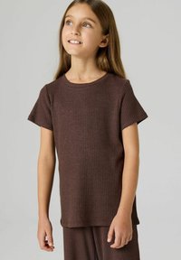 Brązowy prążkowany t-shirt z krótkim rękawem i okrągłym dekoltem. Miękka w dotyku, lekko luźny krój, zestawiony z dopasowanymi spodniami.