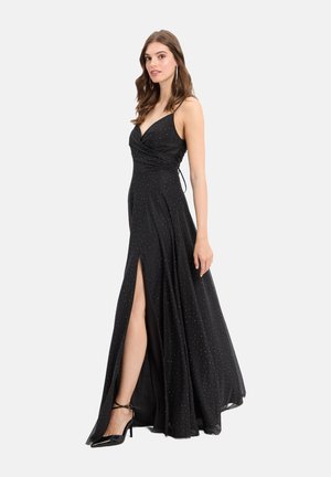 Abito maxi nero con scollo a V profondo, design senza maniche, effetto incrociato in vita e spacco laterale. Decorato con piccoli dettagli argentati.