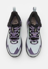 Scarpe da ginnastica grigio chiaro e viola con accenti neri, dotate di una parte superiore testurizzata, motivo a zigzag, sistema di allacciatura e suola in gomma.