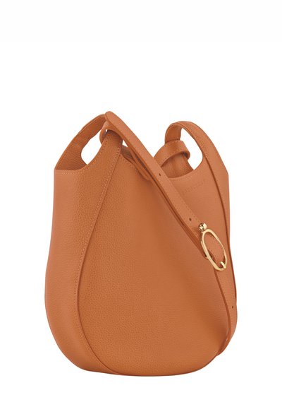 Tan leather handbag with a smooth texture, rounded shape, and a single adjustable strap. Features a gold-tone hardware detail.