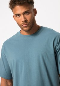 Turquoise ronde hals t-shirt van zachte katoenstof, met een relaxte pasvorm en korte mouwen, met een gladde, egale textuur.
