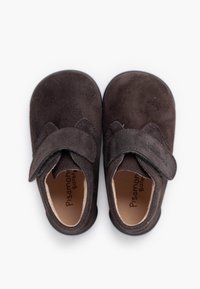 Pantofi maro din piele întoarsă, prevăzuți cu o curea cu Velcro, cu vârf rotund și o parte superioară moale, texturată. Interiorul poartă numele mărcii „Pisamonas Barefoot.”