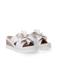 Witte wedge sandalen met een glanzende gouden strikaccent, open teen ontwerp en een gestructureerde witte rubberen zool met stroachtige details.