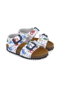 Sandalias infantiles con correas sintéticas blancas que presentan coloridos patrones de dinosaurios. Hebillas ajustables, plantilla de corcho y suela negra texturizada.