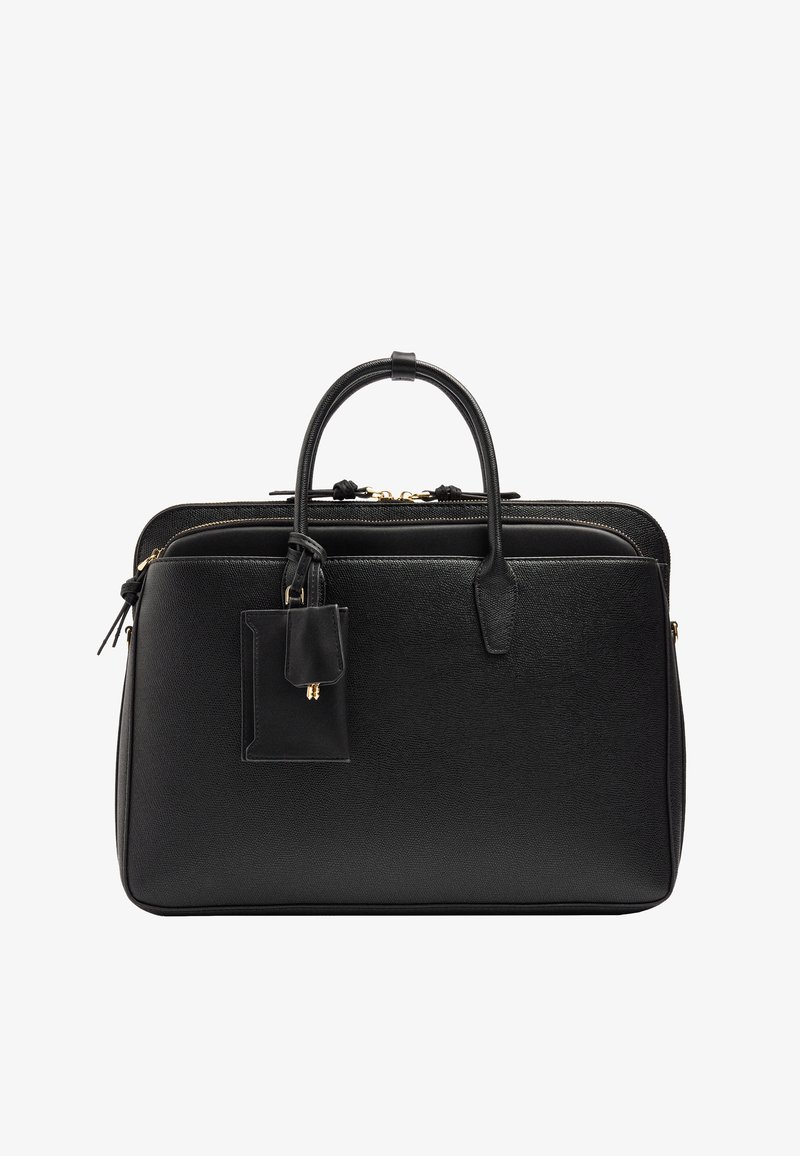 Czarna skórzana aktówka z podwójnymi uchwytami, przednią kieszenią, zamkami błyskawicznymi i przymocowaną metką bagażową na białym tle.