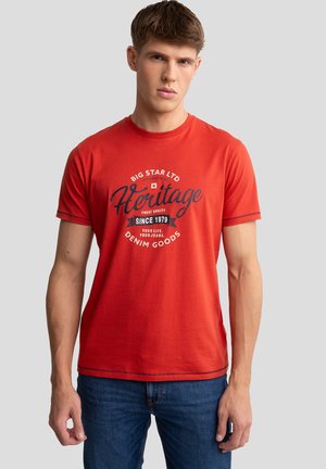 T-shirt in cotone rosso con colletto rotondo, maniche corte e stampa grafica frontale con la scritta "Big Star Ltd Heritage" in colori a contrasto.