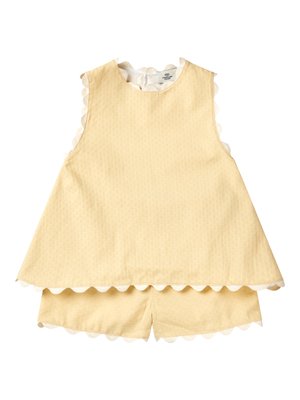 Abito smanicato da bambino in giallo pallido con pantaloncini abbinati, rifiniti con bordo in pizzo bianco smerlato lungo i bordi.