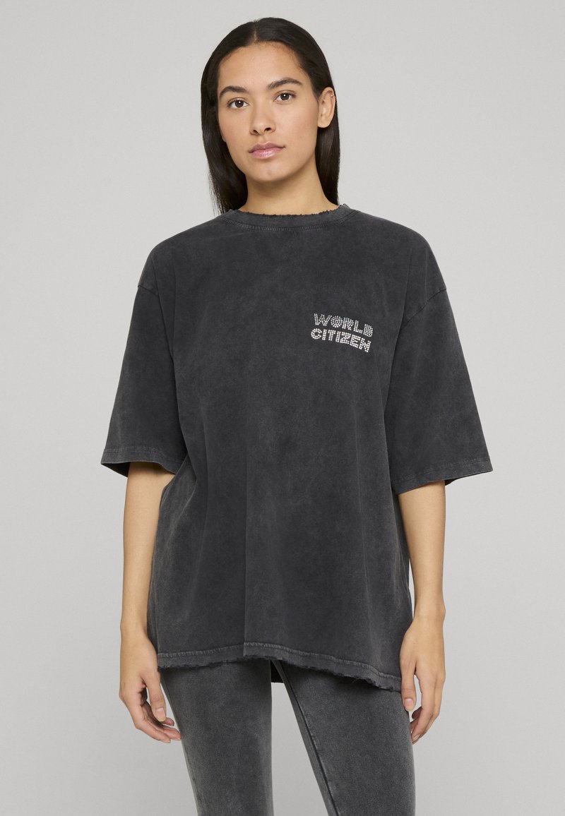 Nadrozměrné tmavě šedé tričko s neupraveným lemem, s malým nápisem "WORLD CITIZEN" zdobeným broušenými kamínky na hrudi.