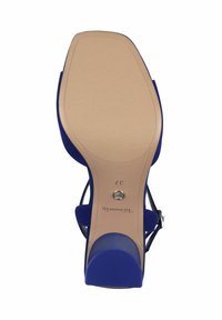 Blå högklackad sandal med en slät, nude gummisula. Har en remdesign med en metallisk accent och en texturerad tådel. Storlek 37.