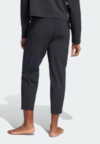 Zwarte cropped broek van gladde stof, met subtiele zijnaden en een ontspannen pasvorm, een rechte zoom en geen zichtbare hardware.