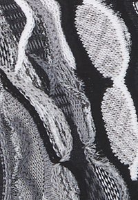 Black and white textile with a wavy pattern, featuring varying textures and intricate weave details, creating a layered appearance.