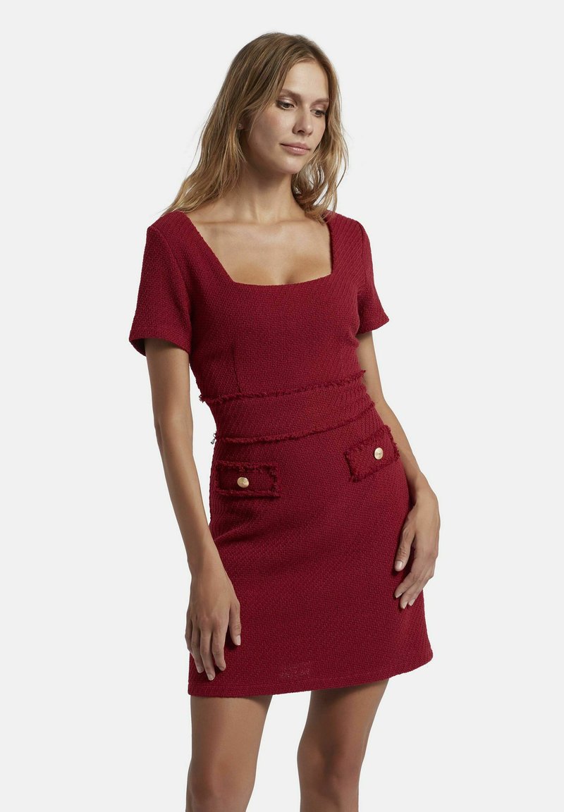 Rotes strukturiertes Kleid mit kurzen Ärmeln, quadratischem Ausschnitt, taillierter Taille und zwei vorderen Taschen mit goldenen Knöpfen und ausgefranstem Rand.