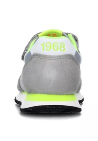 Sneaker in camoscio grigio con dettagli in giallo neon, caratterizzato da un tallone bianco e il numero "1968" stampato in verde brillante sul retro. Suola nera.