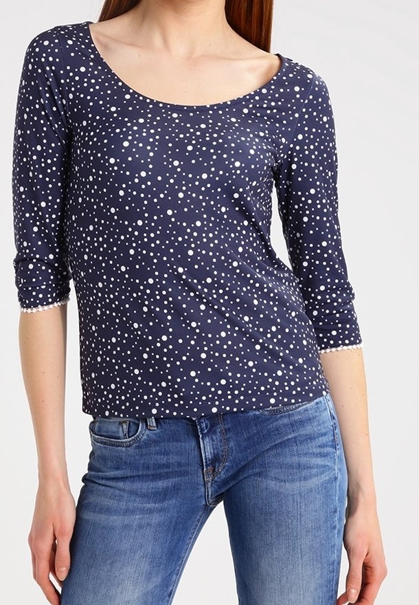 Marineblaue Bluse mit drei Viertelärmeln und weißen Punkten. Hergestellt aus weichem Stoff mit einem Rundhalsausschnitt und subtilen strukturierten Akzenten.