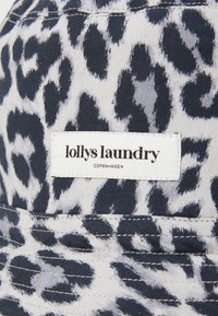 Căciulă tip bucket cu model leopard în nuanțe de bleumarin și gri deschis, având un etichetă albă cu inscripția "lollys laundry, COPENHAGEN." Detaliu de textură și cusătură.