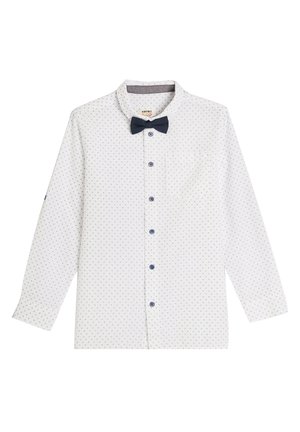 Camicia bianca con bottoni, caratterizzata da un papillon blu navy, piccoli motivi geometrici, una tasca sul petto e bottoni blu. Maniche lunghe con polsini.