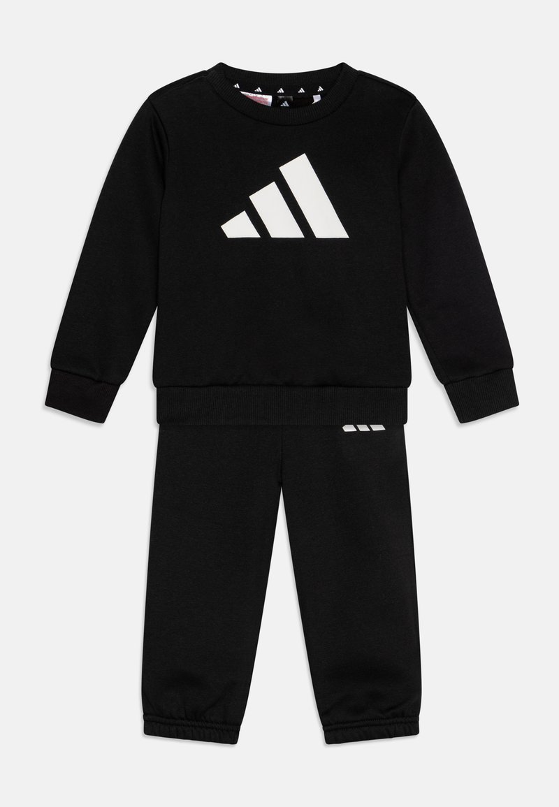 Ensemble sweatshirt et jogging noir en tissu doux, avec un grand logo blanc à trois bandes sur le devant et des accents assortis sur le pantalon.