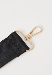 Curea din material textil negru cu un finisaj texturat, având un clips din metal de culoare aurie pentru o prindere sigură.