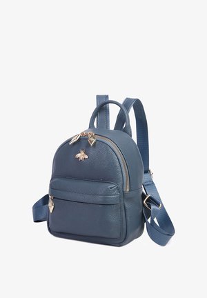 Mały granatowy plecak ze skóry z przednią kieszenią, złotym emblematem pszczoły, złotymi suwakami i regulowanymi paskami na ramiona.