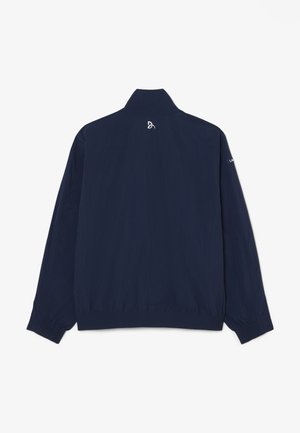Giacca blu navy scuro a maniche lunghe con polsini e vita elasticizzati, piccolo logo bianco vicino al colletto e testo sulla manica destra.